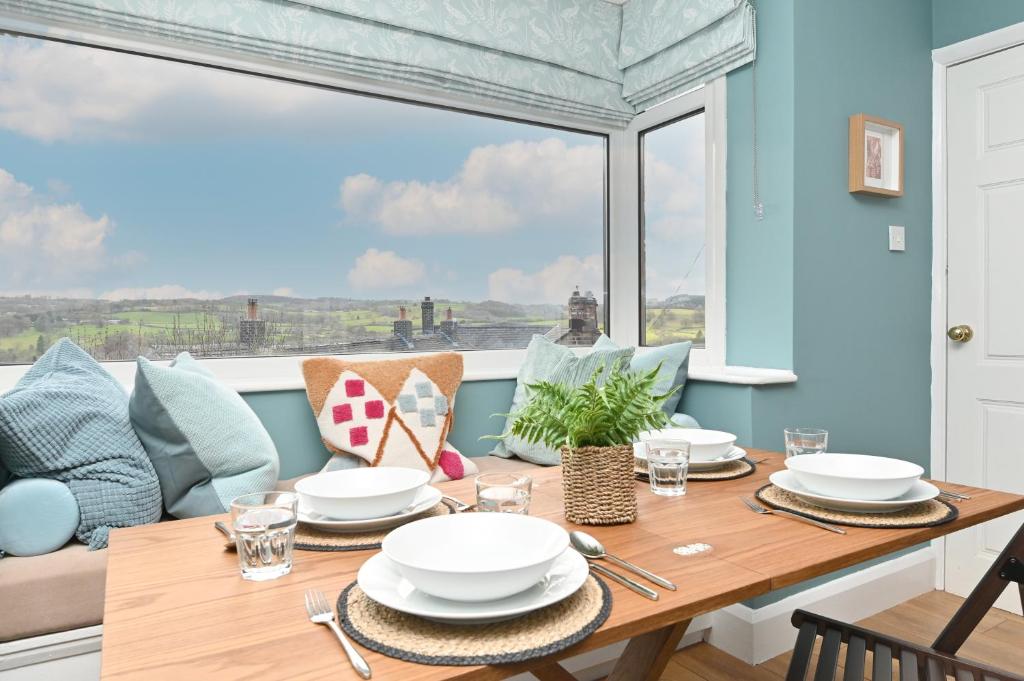 a dining room with a table and a large window at Derwent Valley View in Whatstandwell