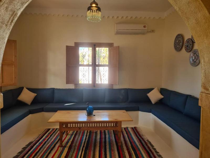 a living room with a blue couch and a table at Villa Louiza in Mezraya