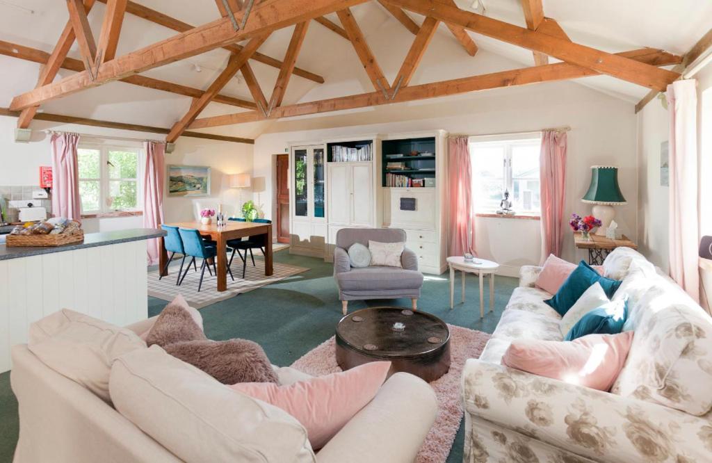 a living room with a couch and a table at Spacious Swallow Cottage in Tisbury