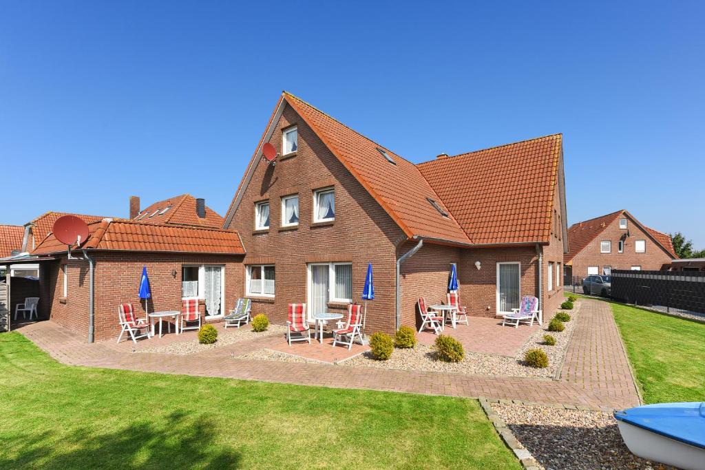 una casa con sedie e tavoli di fronte ad essa di Ferienwohnung Seepferdchen a Bensersiel