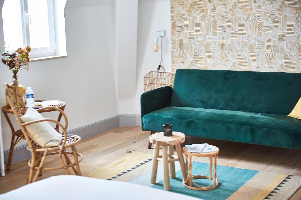 a green couch in a living room with two stools at Demeure de Manneville - SPA - 1Km des plages de Cabourg in Dives-sur-Mer