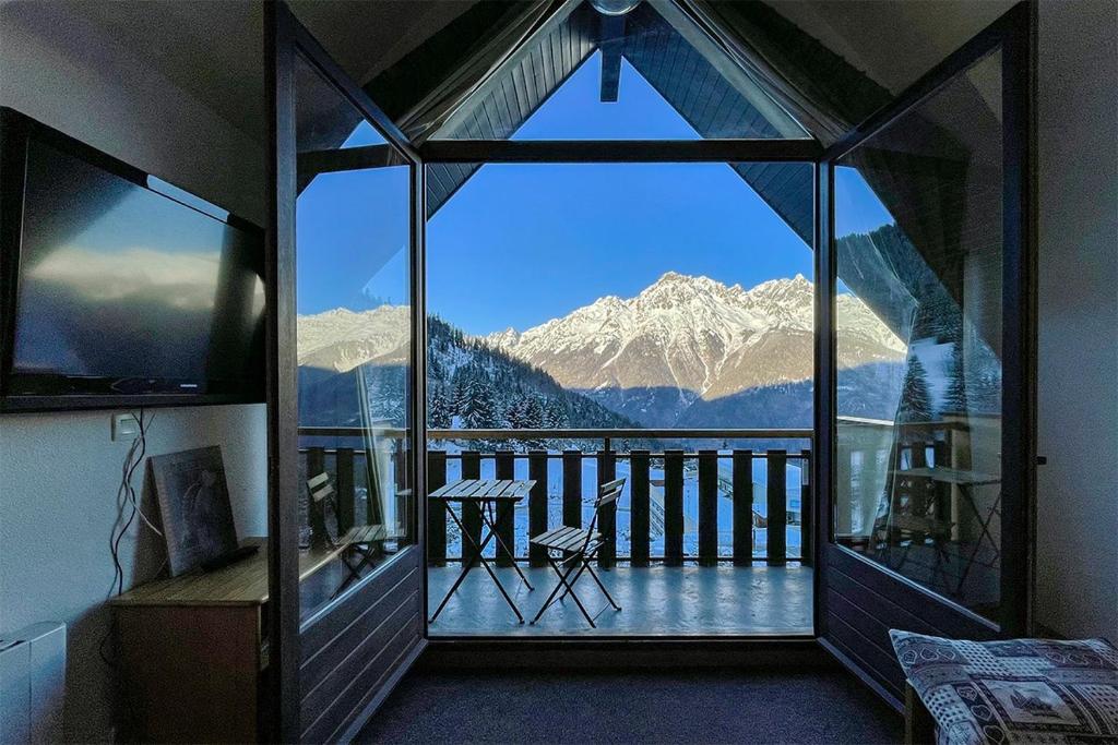 Cette chambre dispose d'une grande fenêtre offrant une vue sur la montagne. dans l'établissement L'Alp'Oz, à Oz
