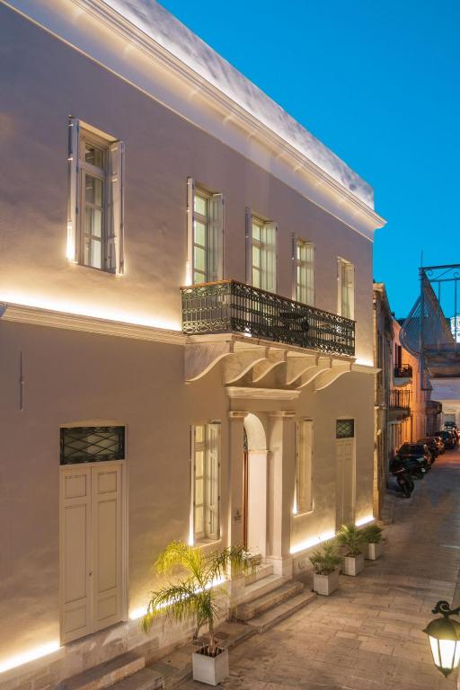 a white building with a balcony on a street at Castro Hotel Syros in Ermoupoli
