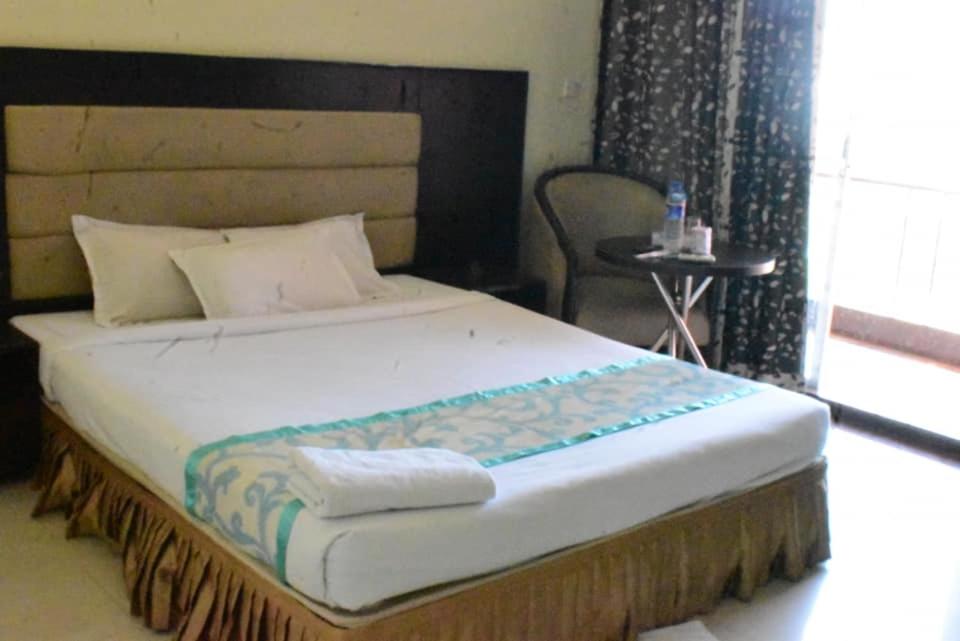 Cette chambre comprend un grand lit et une chaise. dans l'établissement Coastal Peace, à Cox's Bazar