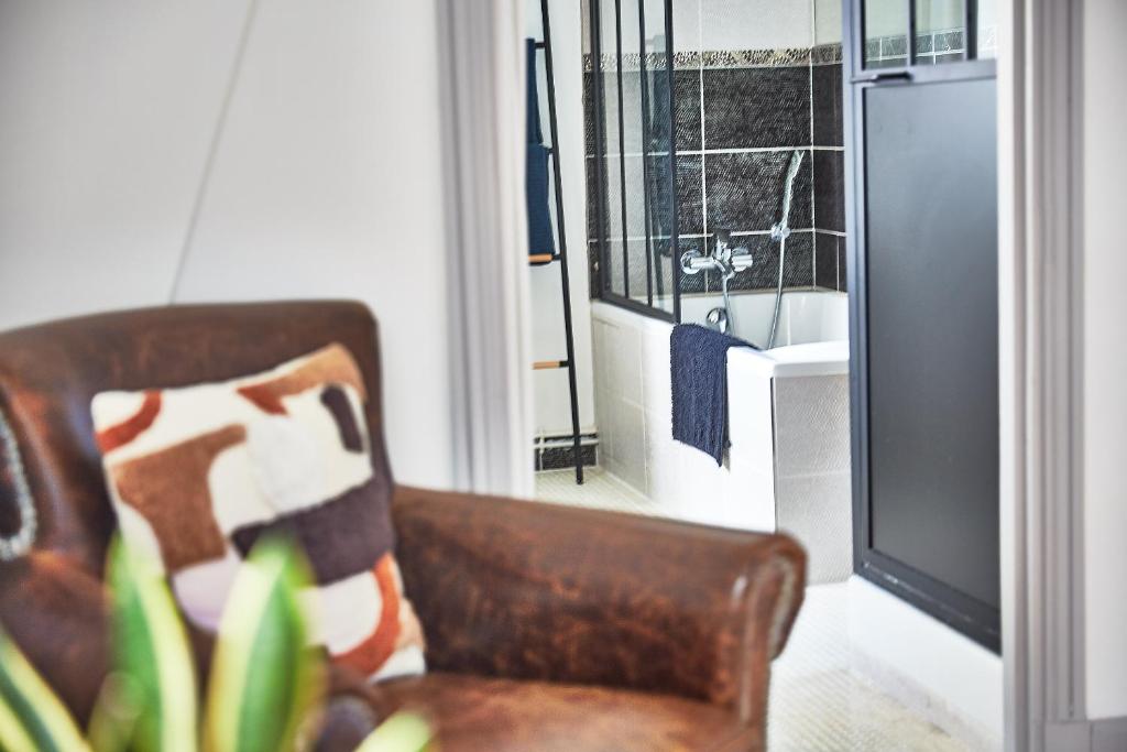 a living room with a chair and a window at Demeure de Manneville - SPA - 1Km des plages de Cabourg in Dives-sur-Mer