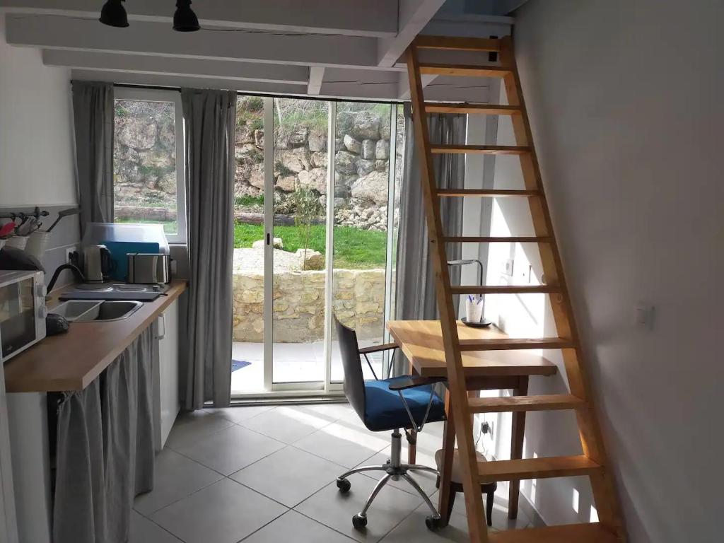 a desk and a chair in a room with a ladder at Logement entier dans village calme in Guillerval
