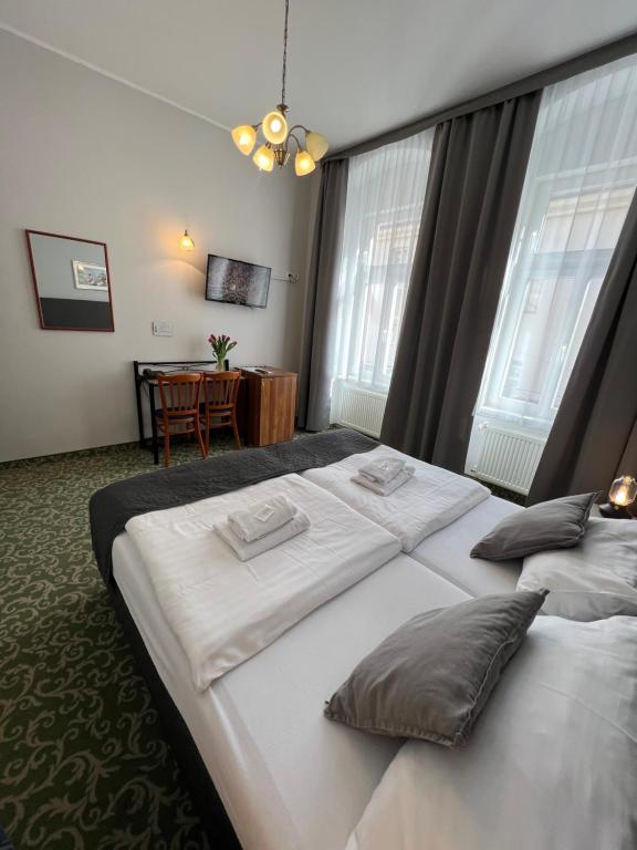 a hotel room with two beds and a table at Hotel Boston in Karlovy Vary