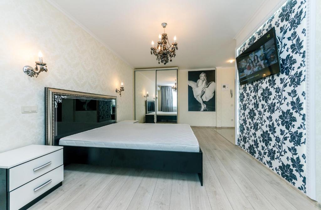 a bedroom with a large bed and a chandelier at LuxCenterApartment in Kyiv