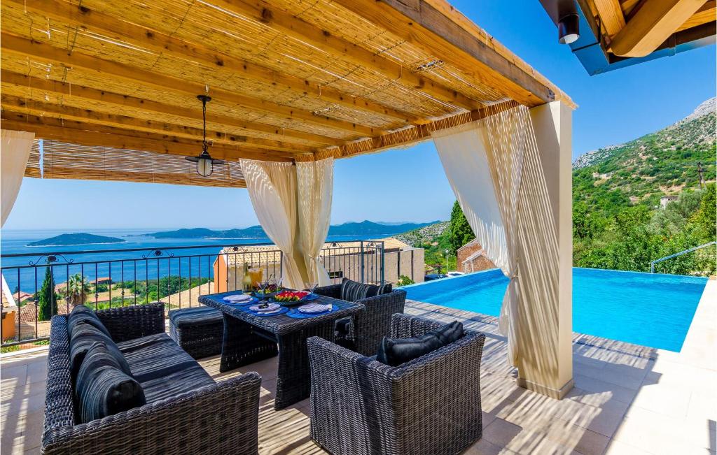 a patio with a table and chairs and a pool at Stunning Home In Brsecine With Outdoor Swimming Pool in Brsečine