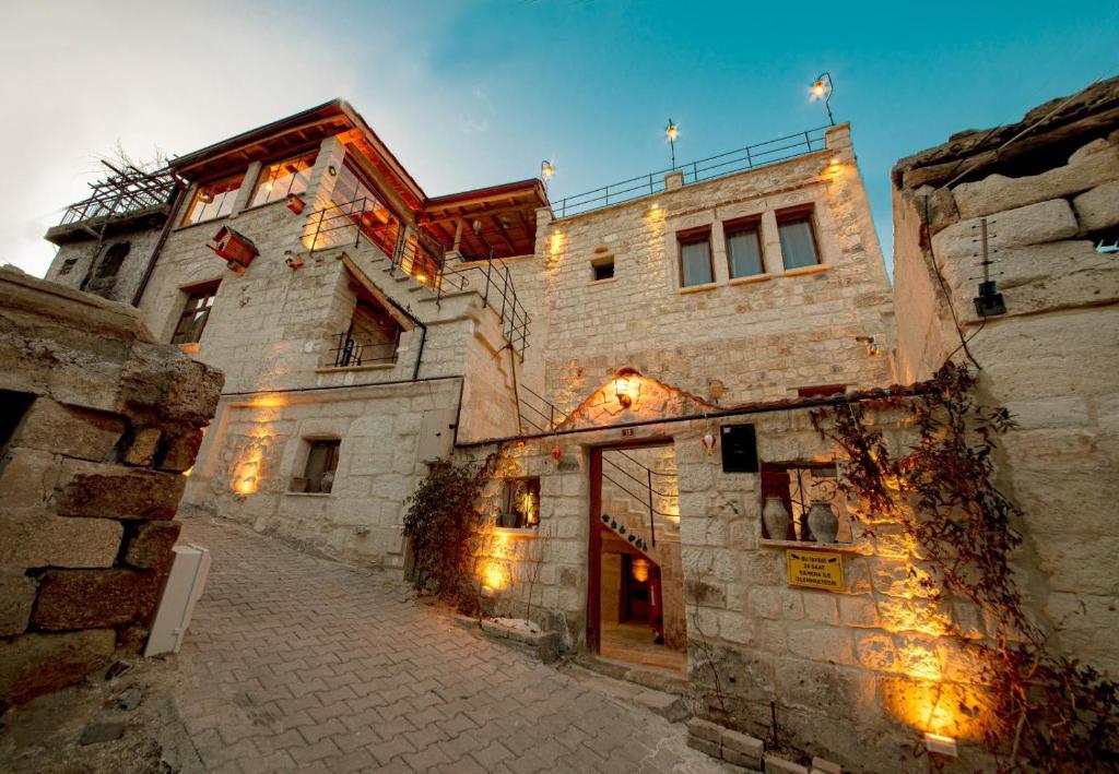 an old stone building with lights on a street at Zula Cave House in Ürgüp