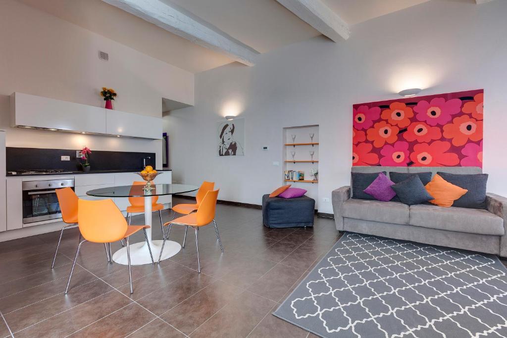un soggiorno con divano, tavolo e sedie di Glam Apartments a Firenze