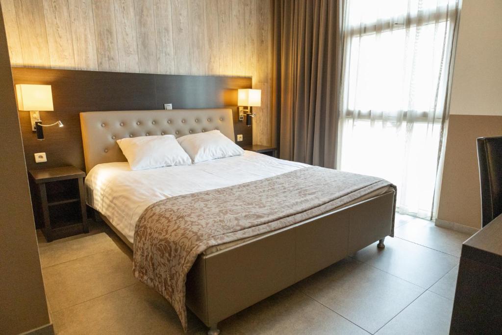 1 dormitorio con cama y ventana grande en Hotel De Maaskant, en Maaseik