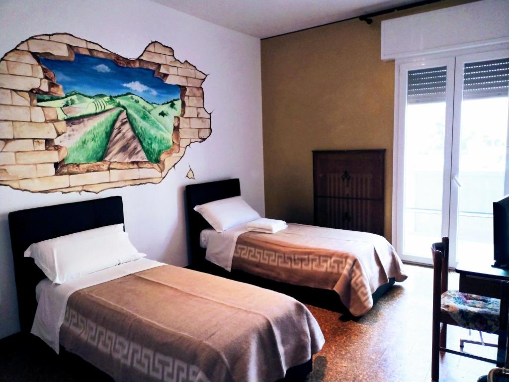 a room with two beds and a mural on the wall at Affittacamere di Andrea Bertolino Anzola dell'Emilia in Anzola dell'Emilia