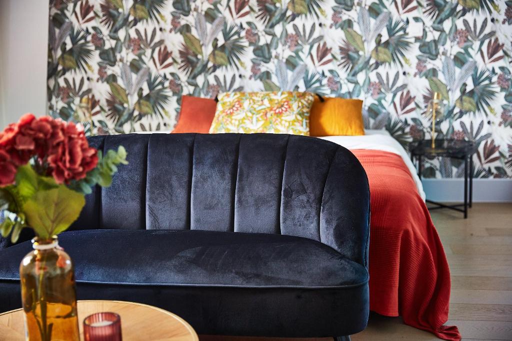 a black leather couch in a living room with a bed at Demeure de Manneville - SPA - 1Km des plages de Cabourg in Dives-sur-Mer
