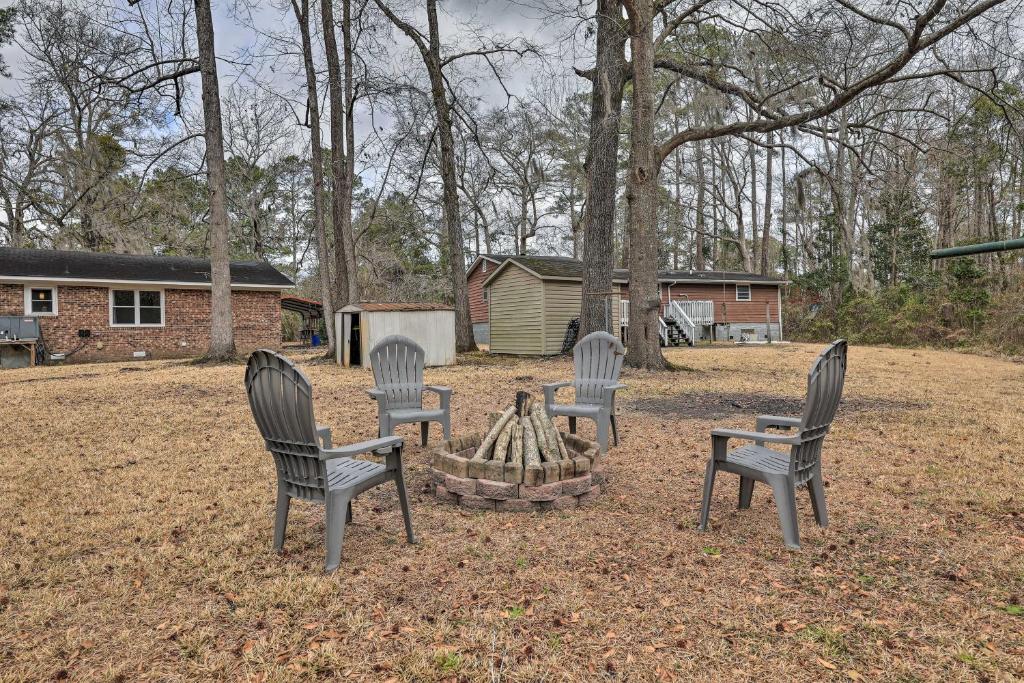 four chairs sitting around a fire pit in a yard at Dog-Friendly House with Yard Near Boat Launch! in New Bern