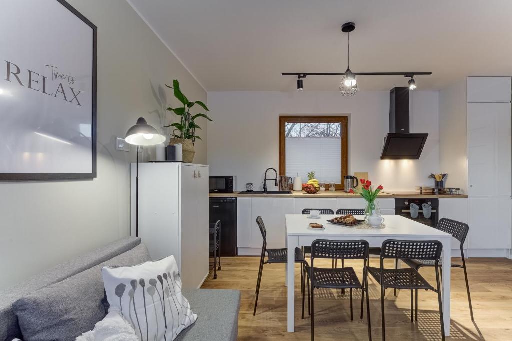 a kitchen and a living room with a table and chairs at Przy Cegielni in Tylicz