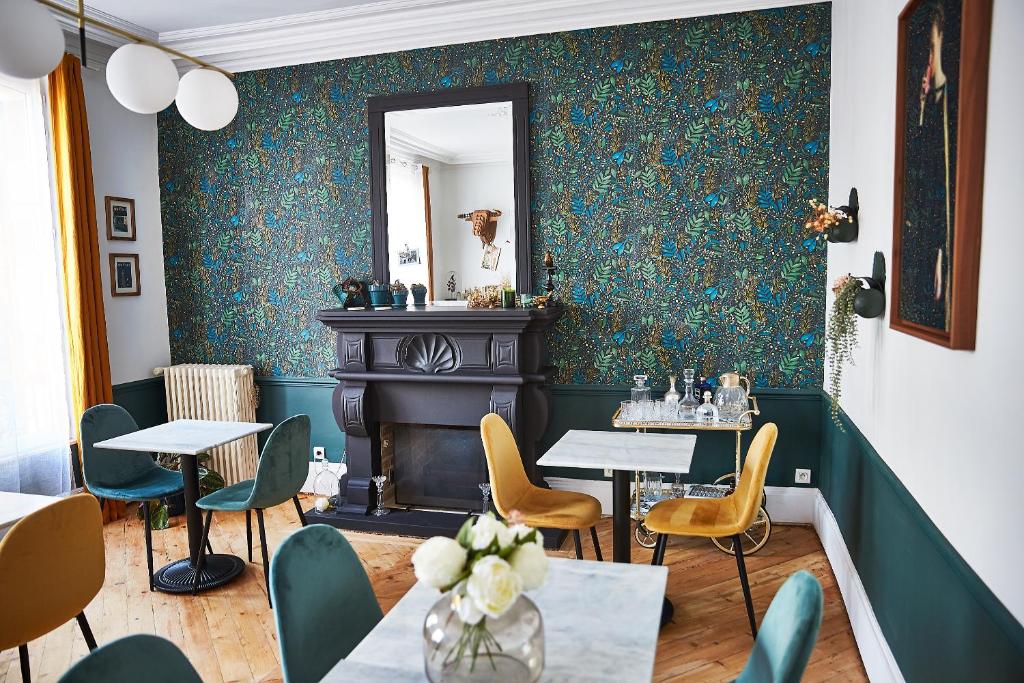 a restaurant with green walls and tables and chairs at Demeure de Manneville - SPA - 1Km des plages de Cabourg in Dives-sur-Mer