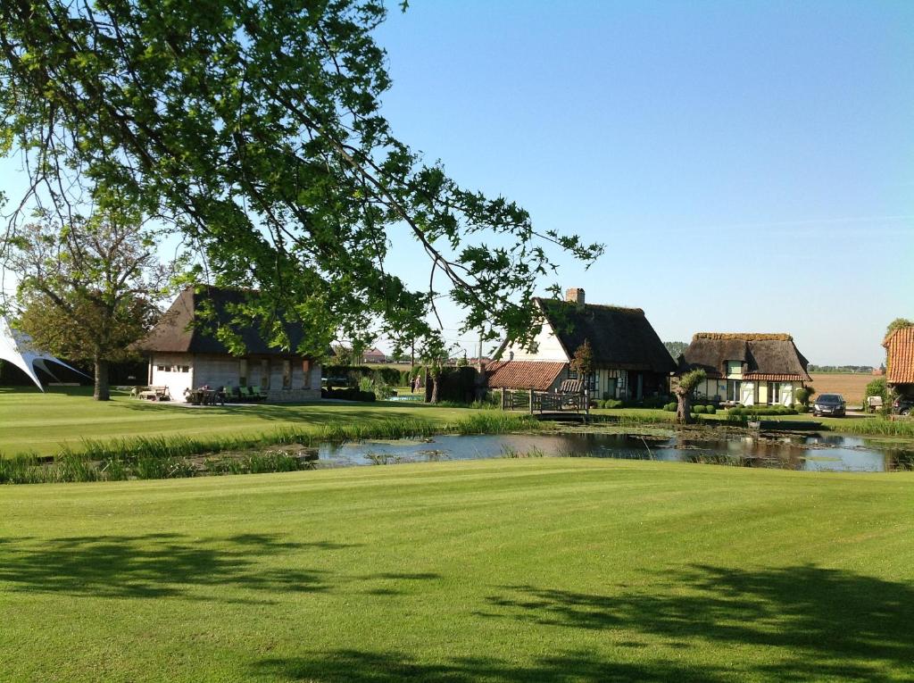 a house on a golf course with a pond at Sint-Coryn in Reninge