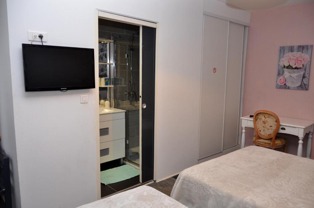 una camera con un letto e una televisione a parete di Aux Lys d'Or a Réalville