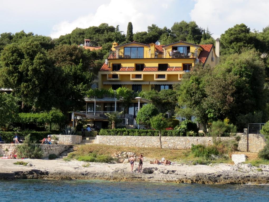 a building on a hill next to the water at Apartments Figarola in Rovinj