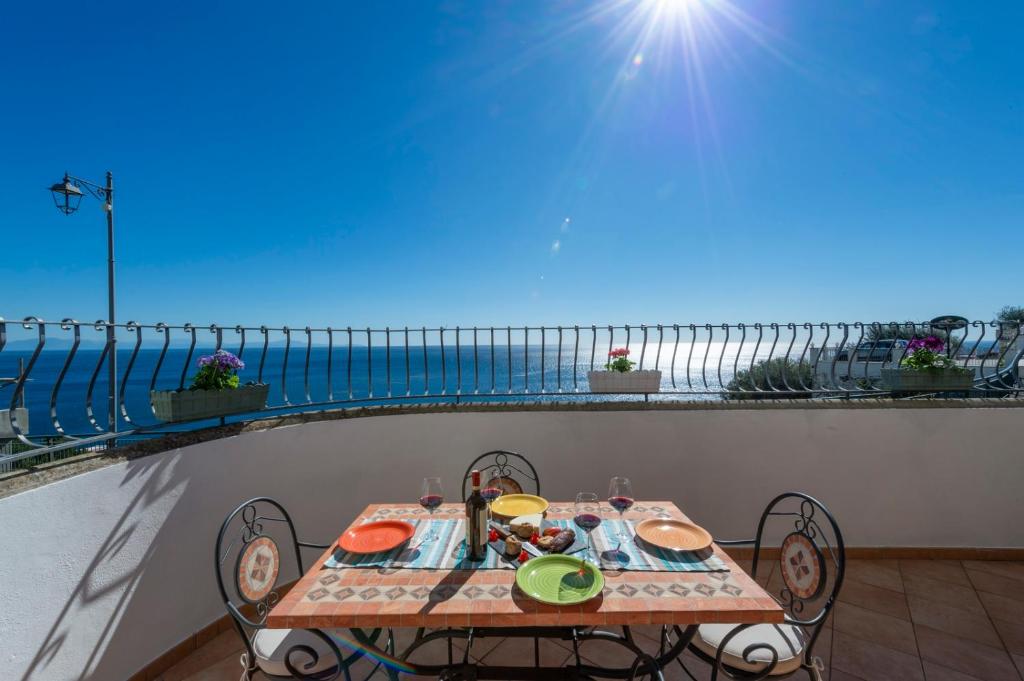 una mesa en un balcón con vistas al océano en House in the center at 250mt from the beach with a private parking en Praiano