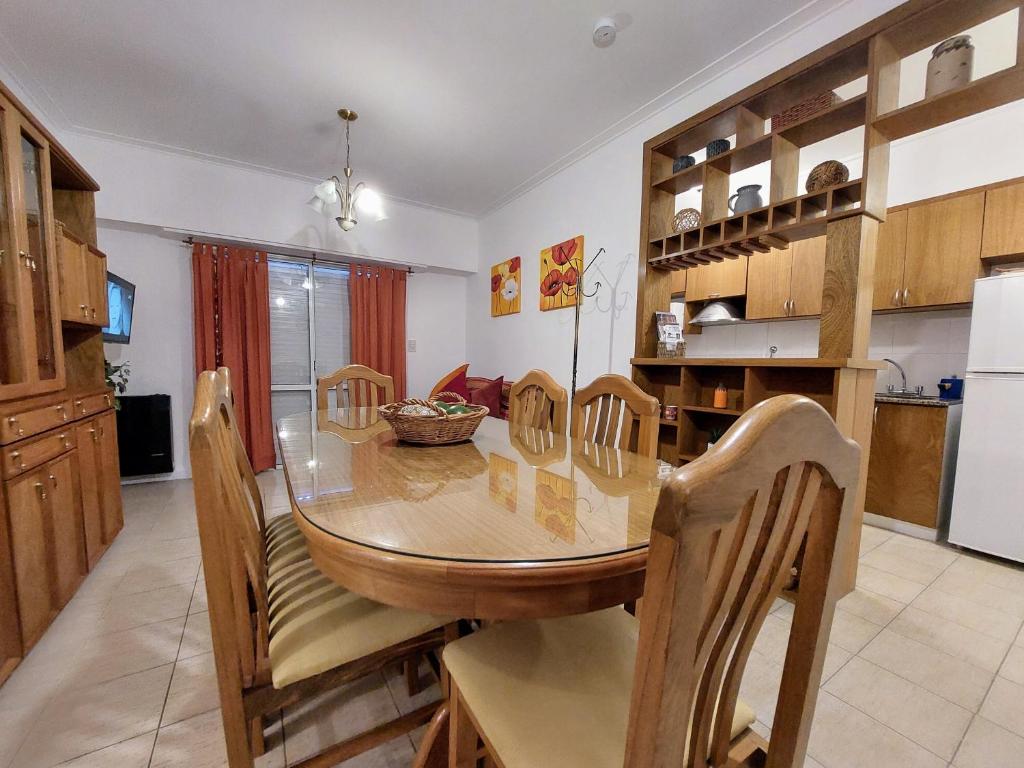 a kitchen with a wooden table and chairs around it at Dpto. luminoso, céntrico, nuevo: LA SERENA in Tandil