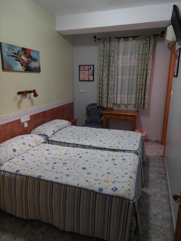 a hotel room with two beds in a bedroom at Pensión Colonia in Motril