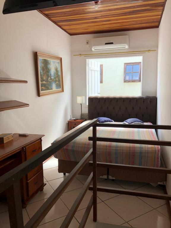 a bedroom with a bunk bed and a desk and a bed at Flat lindo paraty in Paraty