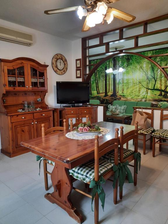 a dining room with a wooden table and chairs at Appartamento Domusnovas in Domusnovas