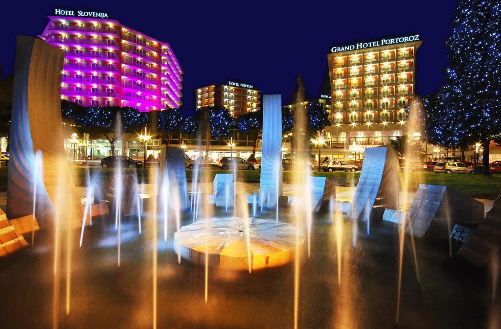 a water fountain in a city at night at Hotel Neptun - Terme & Wellness Lifeclass in Portorož