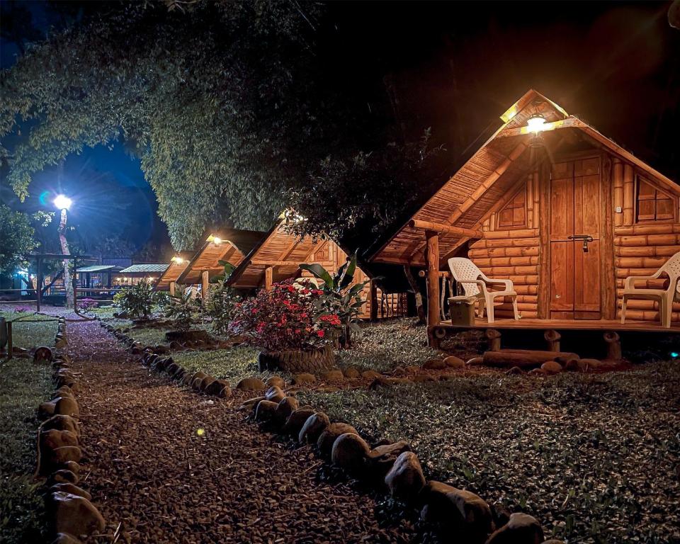 una fila de cabañas de madera por la noche en Camping lagos de venecia, en Santa Rosa de Cabal