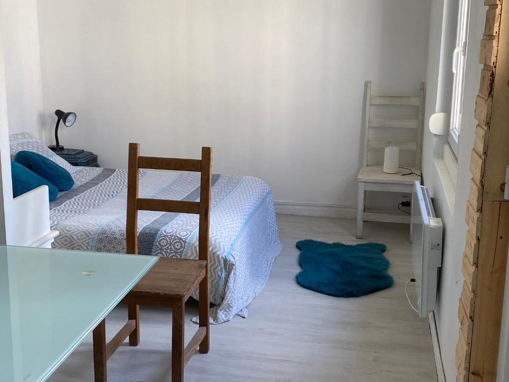 a room with a table and a chair and a bed at Adorable Gesthouse avec parking gratuit sur place. in Le Chêne