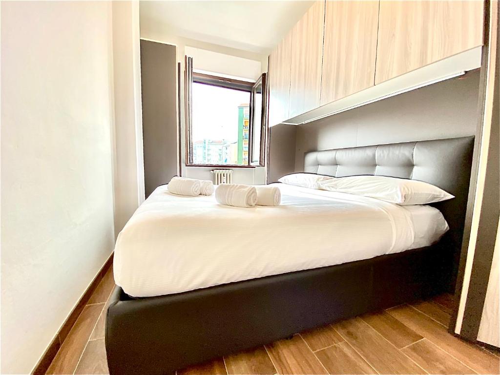 a bedroom with a large white bed with a window at 15 minuti dall'Istituto Ortopedico Galeazzi - Appartamento Silenzioso con Cucina, WiFi e Netflix in Milan