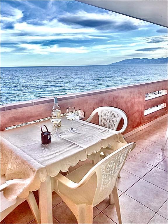 a table and chairs on a balcony overlooking the ocean at belvedere acqua dolce 1 in Cala Gonone