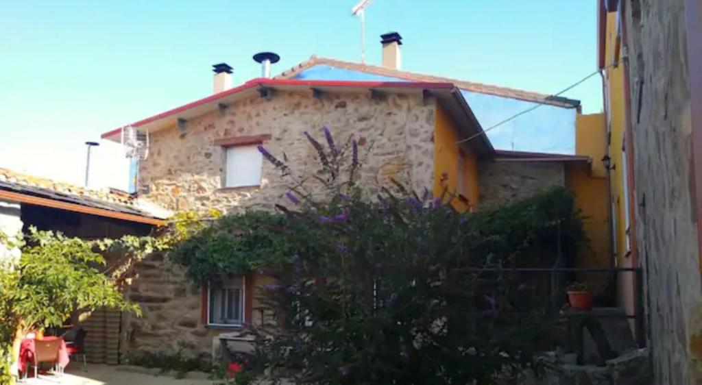 a stone house with flowers in front of it at El Zoela in Zamora