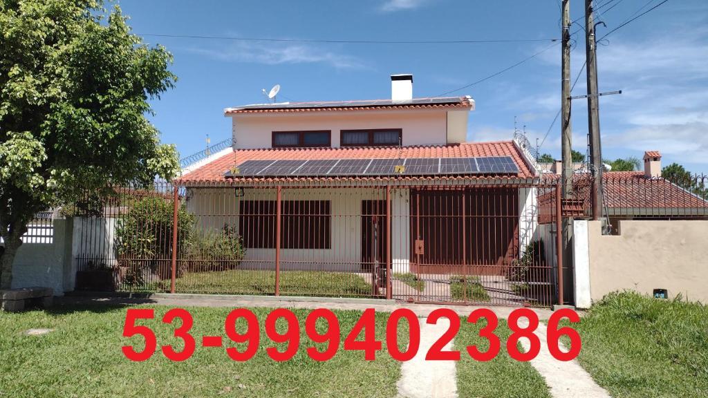 una casa con un cartel de precio delante en Casa Ampla 2 dormitorios LARANJAL temporada, en Pelotas