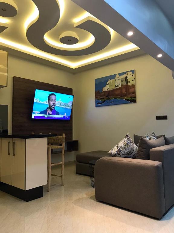 Una sala de estar con un sofá y un televisor de pantalla plana. en Pedro Appartement, en Essaouira
