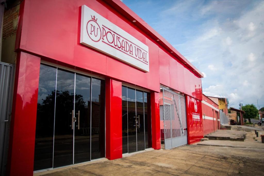 een rood gebouw met een bord aan de zijkant bij Pousada Vidal in Carolina
