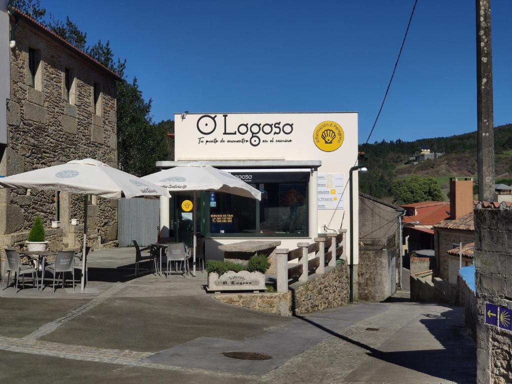 a food truck with tables and umbrellas outside at Albergue O Logoso in Campelo