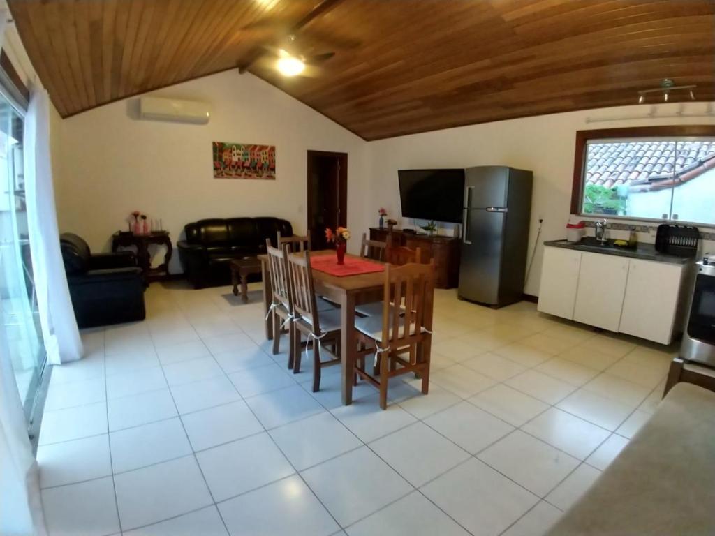 a kitchen and living room with a table and chairs at Apartamento Exclusivo Búzios Centro in Búzios