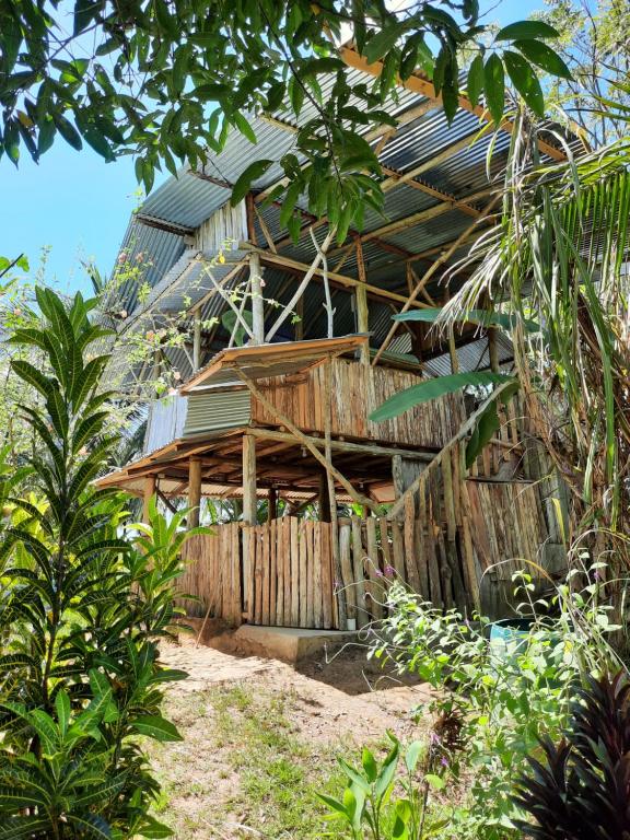 ein Haus mit einem Holzzaun davor in der Unterkunft La Muñequita Lodge 2 - culture & nature experience in Palmar Sur