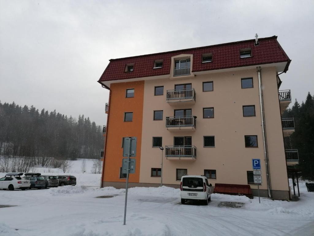 un gran edificio con coches estacionados en un estacionamiento en Apartmán 68 Horní Lipová, en Lipová-lázně