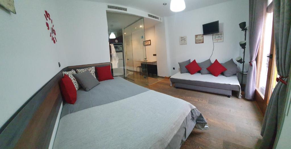 um quarto com uma cama e um sofá num quarto em Apartamento centro Málaga em Málaga