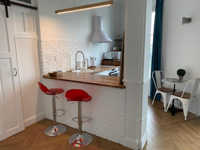 une cuisine avec deux tabourets rouges et un comptoir dans l'établissement L'ALBERT 1er - Ancien Palace - Centre ville - Terrasse, à Vichy