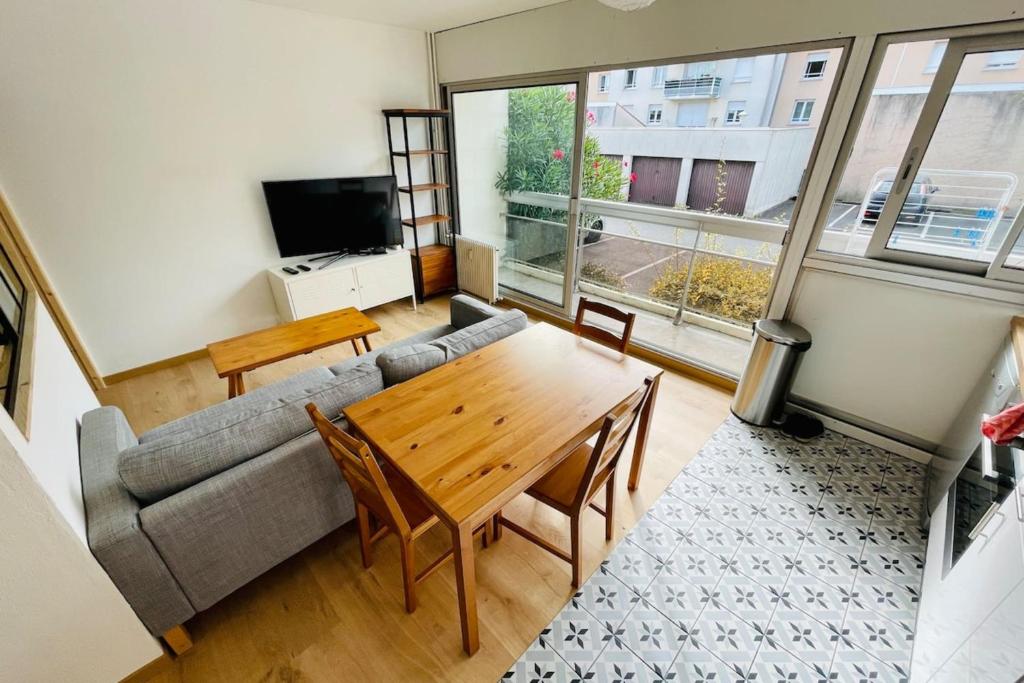 salon ze stołem i kanapą w obiekcie Furnished Apartment With Balcony & Parking in A Secure Residence w mieście Pessac