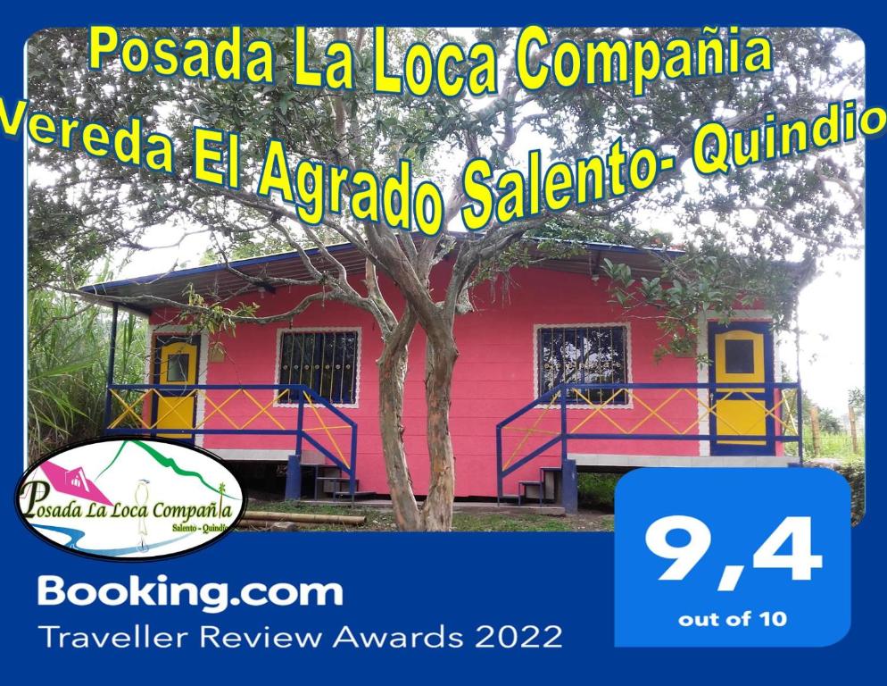 une maison rose avec un arbre devant elle dans l'établissement Posada La Loca Compañía, à Salento
