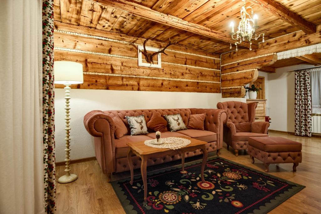 ein Wohnzimmer mit einem Sofa und einem Tisch in der Unterkunft Chata Litwor in Bukowina Tatrzańska