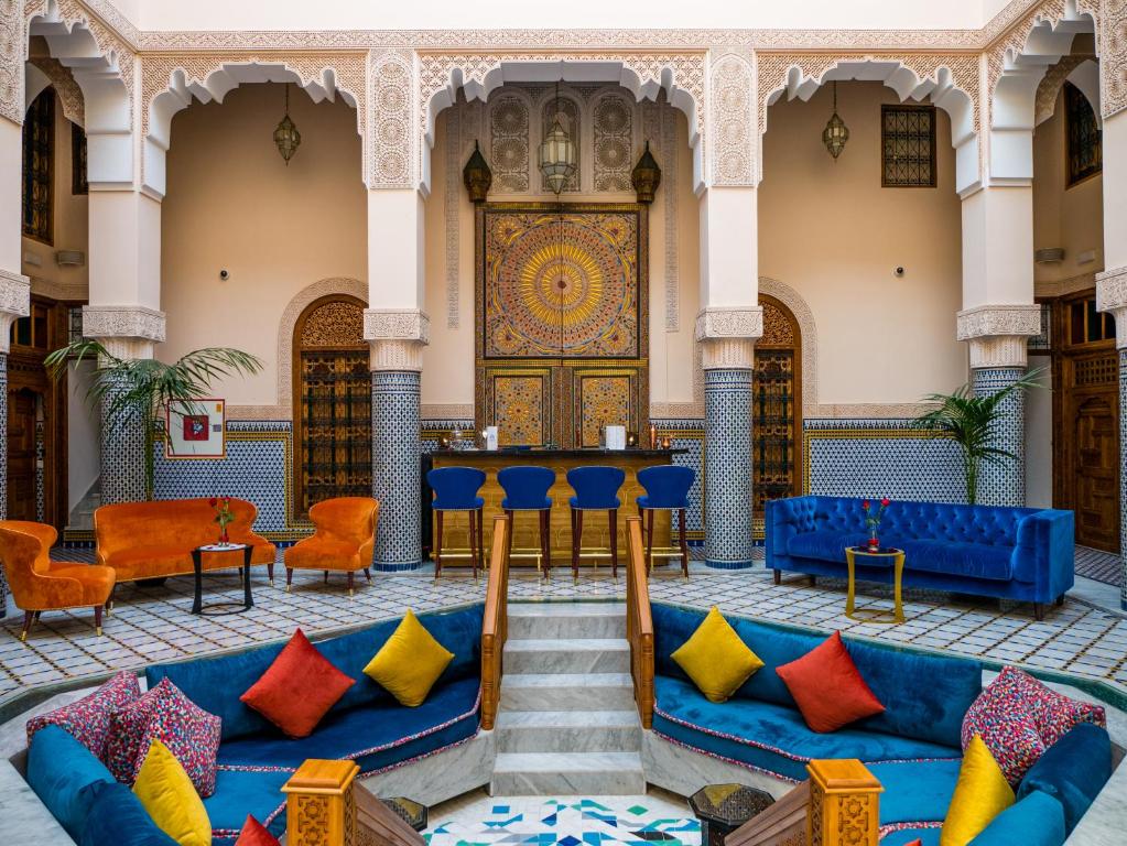 Riad El Amine Fès في فاس: غرفة مع الأرائك الزرقاء والوسائد الملونة