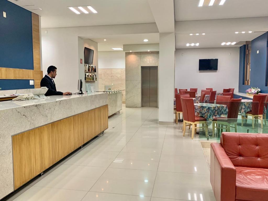 a man sitting at a counter in a hospital lobby at Rymma Hotel in Morelia
