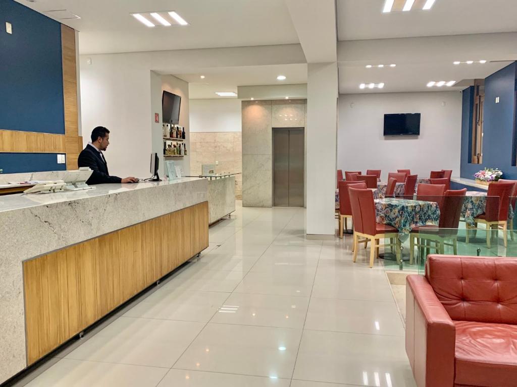 mężczyzna siedzący przy ladzie w szpitalnym holu w obiekcie Rymma Hotel w mieście Morelia